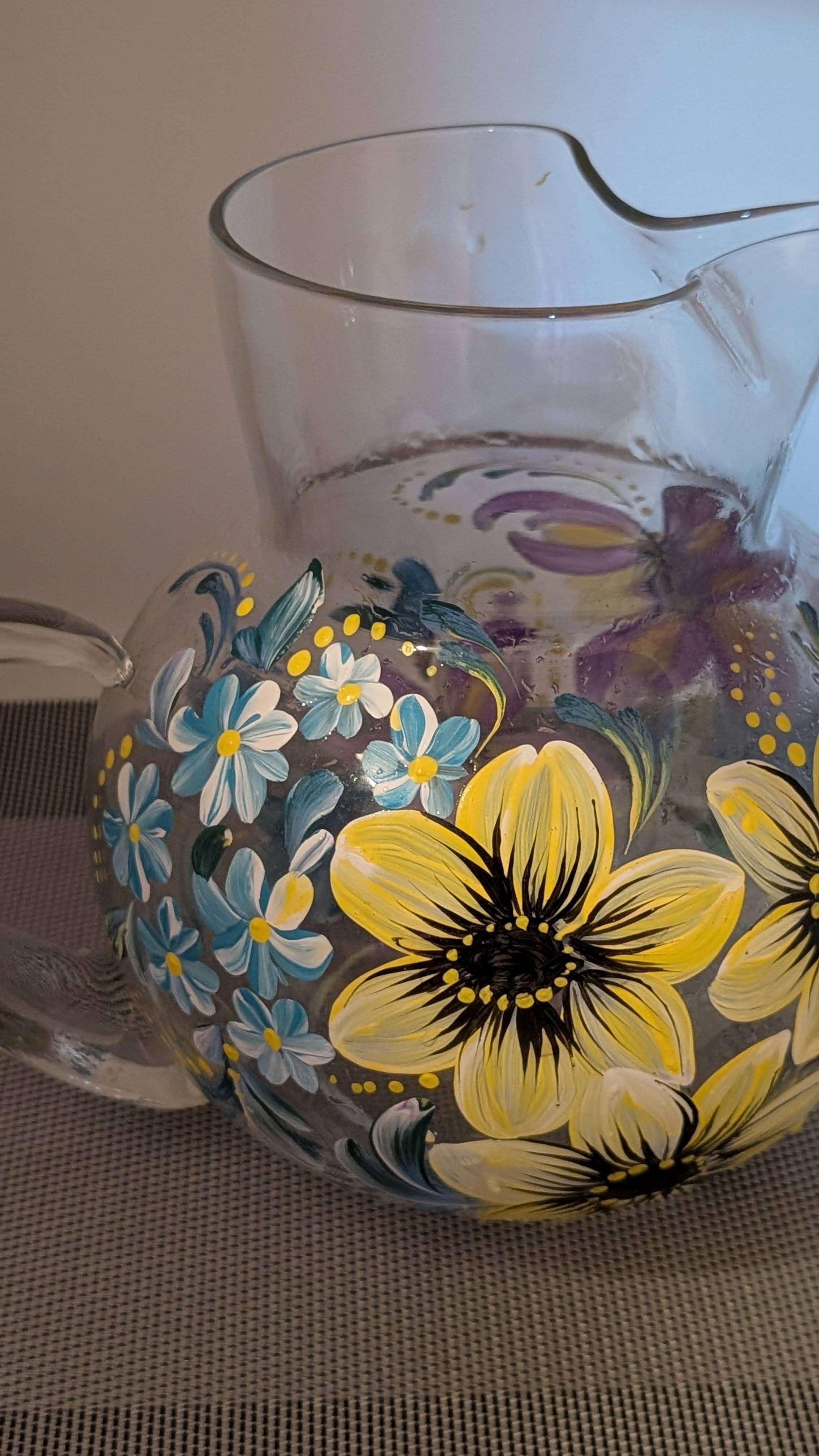 Glass pitcher with yellow sunflowers and blue accents